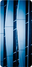 A close-up, abstract view of a modern building facade with blue-tinted glass and geometric lines.