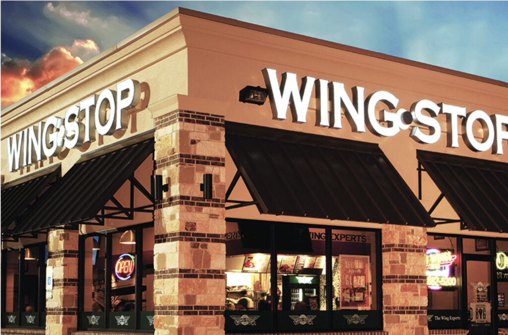 A close-up, eye-level shot of the exterior of a Wingstop restaurant at dusk.